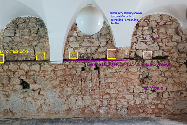 Místnost 004 – východní obvodová zeď místnosti zbavená omítek s patrnými nálezovými situacemi (přízemí a patro zděného komorového dílu středověkého domu s pozůstatky původního dřevěného trámového stropu). Foto Petra Kaniová, NPÚ ÚOP v Ostravě, 2022.