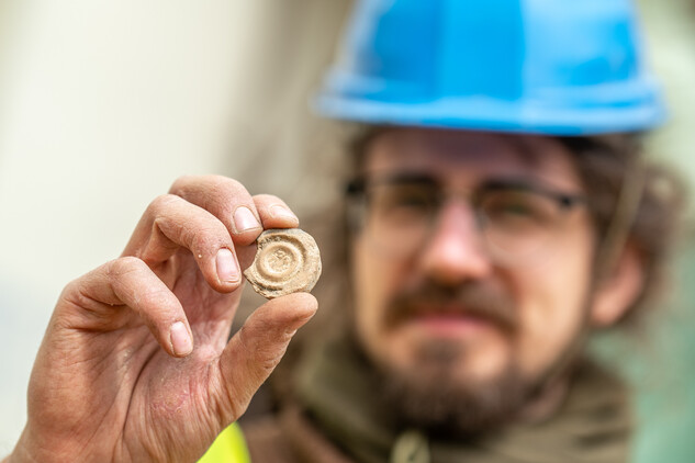 Výzkum středověké odpadní jímky – momentka z nálezu části formy na odlévání razidla, foto: Jakub Koumar